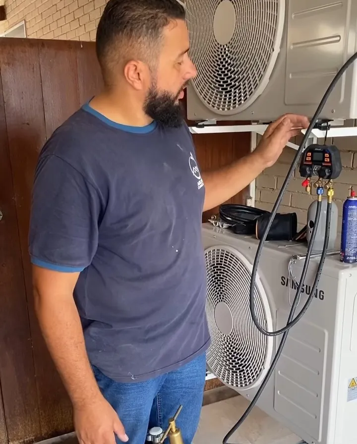 Técnico fazendo o teste de estanqueidade com cilindro de nitrogênio e manifold ao lado das condensadoras